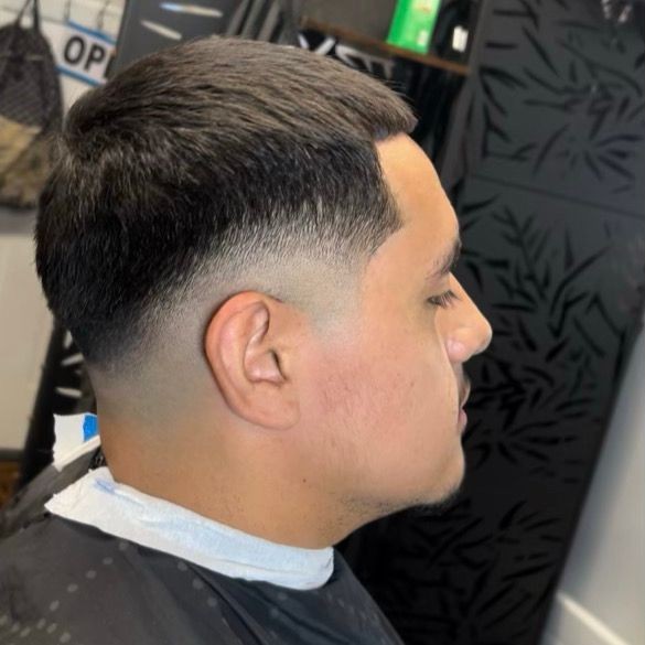 Side view of a man with a fresh fade haircut in a barber shop.